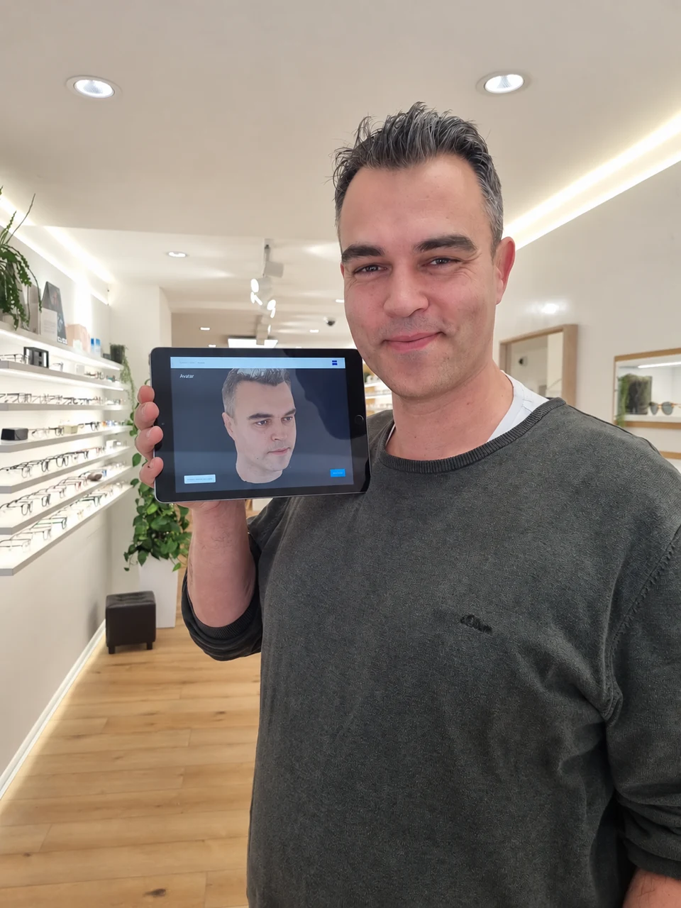 Tobias Glaab zeigt seinen mit ZEISS VISUFIT 1000 erstellten Avatar auf einem Tablet