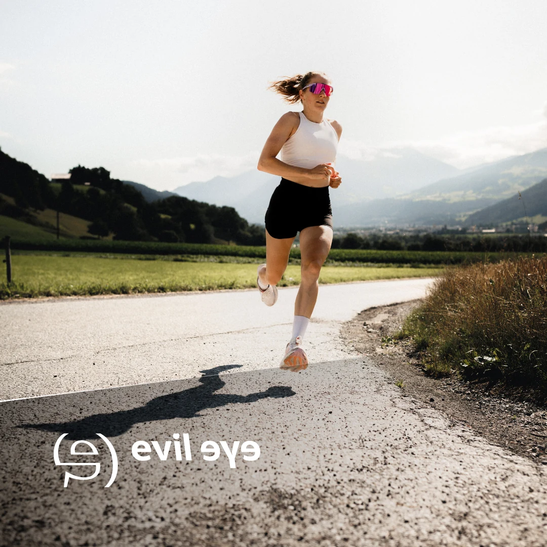 Läuferin mit evil eye Sportbrille auf einem Weg in den Bergen